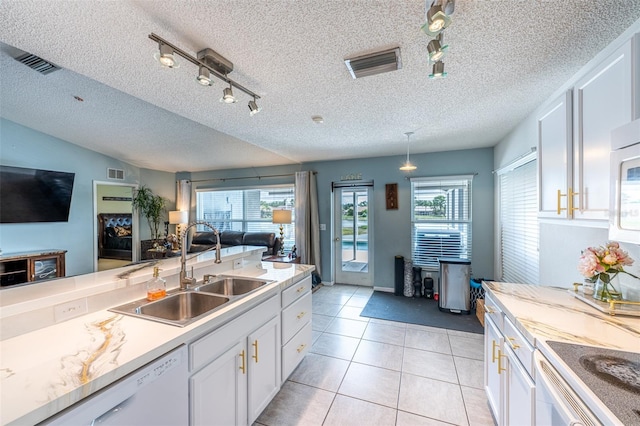 12026 Warwick Cir, Parrish, FL 34219 - kitchen featuring white cabinetry, plenty of natural light, open floor plan, rail lighting, and a textured ceiling