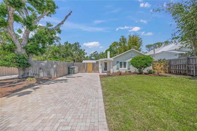 2537 Ashton Rd, Sarasota, FL 34231 - view of front facade with decorative driveway, a gate, a front lawn, and a fenced front yard