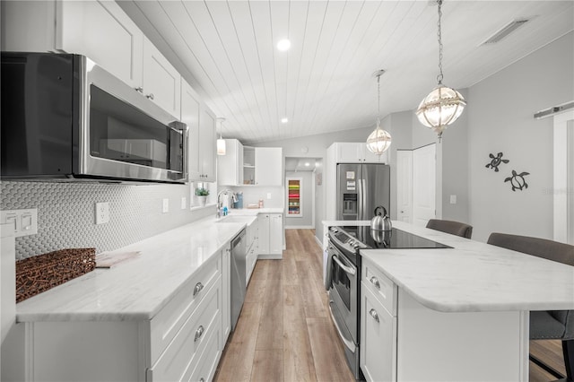 2537 Ashton Rd, Sarasota, FL 34231 - kitchen with a breakfast bar, appliances with stainless steel finishes, light wood finished floors, a sink, and visible vents