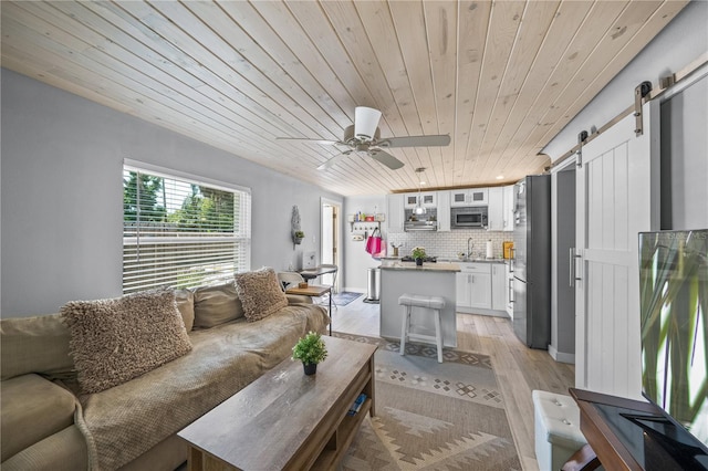 2537 Ashton Rd, Sarasota, FL 34231 - living area featuring light wood-type flooring, a ceiling fan, a barn door, and wood ceiling