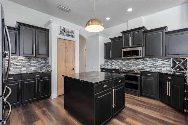 3806 155th Ave E, Parrish, FL 34219 - kitchen with dark cabinets, appliances with stainless steel finishes, a center island, dark wood-style flooring, and a textured ceiling