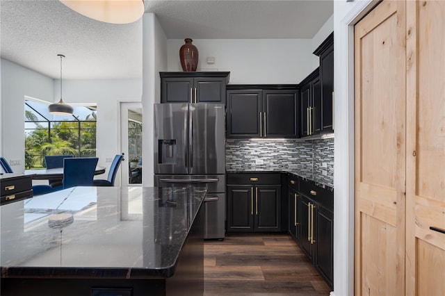 3806 155th Ave E, Parrish, FL 34219 - kitchen with stainless steel refrigerator with ice dispenser, dark wood finished floors, dark stone counters, backsplash, and a textured ceiling
