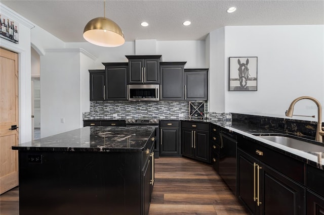 3806 155th Ave E, Parrish, FL 34219 - kitchen with stainless steel appliances, dark cabinets, dark wood-type flooring, a kitchen island, and arched walkways