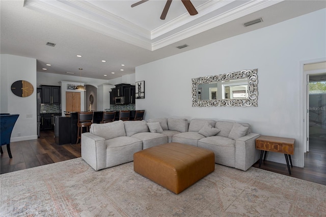 3806 155th Ave E, Parrish, FL 34219 - living room with dark wood-style floors, a ceiling fan, crown molding, a tray ceiling, and recessed lighting