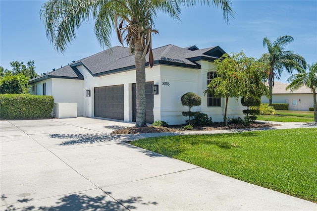 3806 155th Ave E, Parrish, FL 34219 - view of front of home with stucco siding, a garage, concrete driveway, a front lawn, and roof with shingles