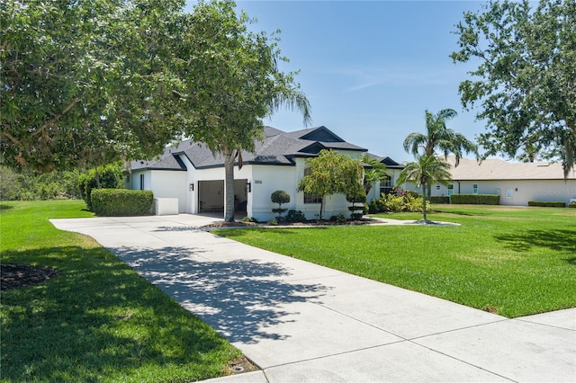 3806 155th Ave E, Parrish, FL 34219 - ranch-style home with concrete driveway, a front yard, stucco siding, and an attached garage