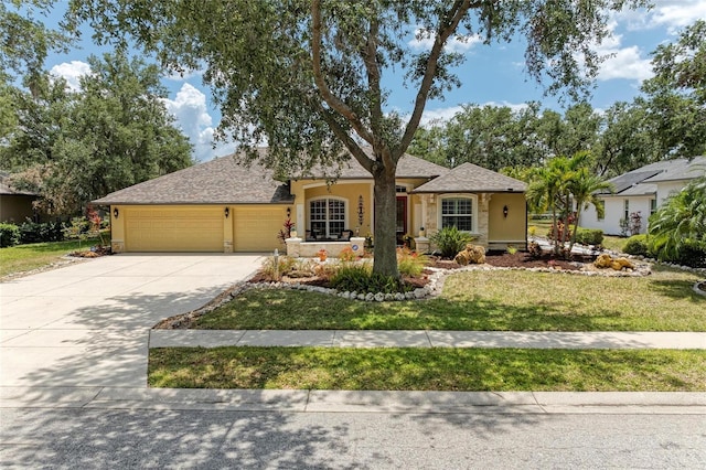 single story home with concrete driveway, an attached garage, a front yard, and stucco siding