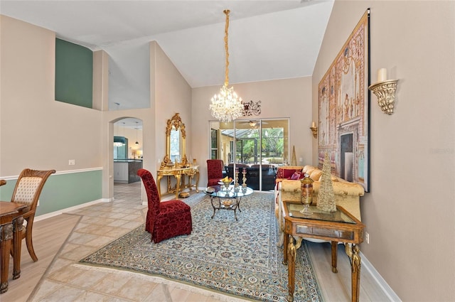 living room with arched walkways, high vaulted ceiling, a notable chandelier, and baseboards
