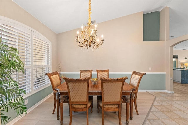 dining space featuring arched walkways, baseboards, an inviting chandelier, and visible vents