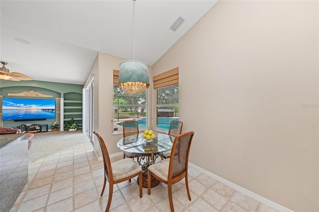 dining space with ceiling fan with notable chandelier, baseboards, vaulted ceiling, and visible vents