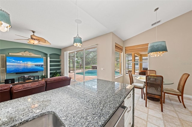 kitchen featuring stone counters, visible vents, open floor plan, and decorative light fixtures