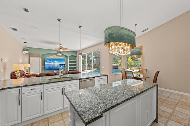 kitchen with ceiling fan, a sink, a center island, stainless steel dishwasher, and visible vents