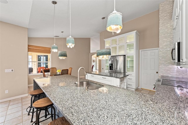 kitchen featuring a sink, appliances with stainless steel finishes, a breakfast bar area, and light tile patterned flooring