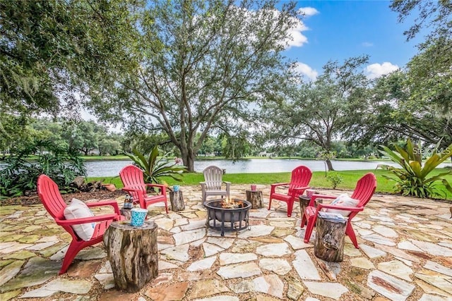 view of patio with a water view and a fire pit