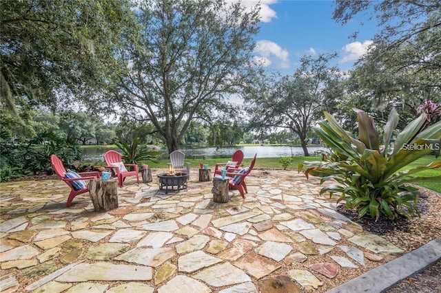 view of patio with a water view and a fire pit