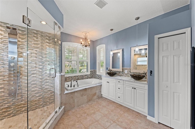 full bath featuring visible vents, a shower stall, an inviting chandelier, and a garden tub