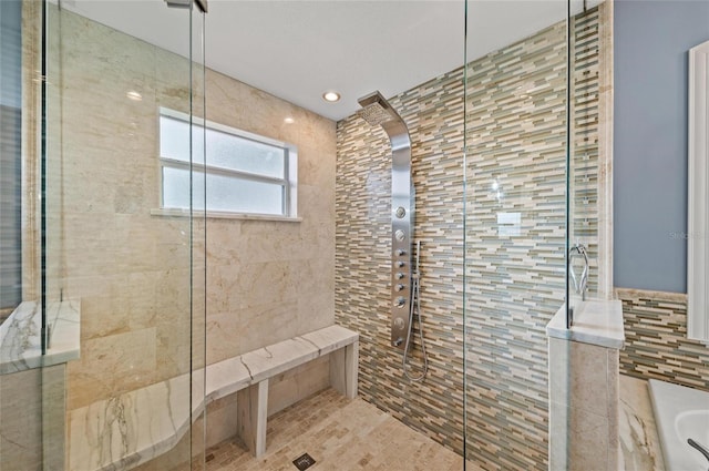 full bath featuring recessed lighting, tile walls, and tiled shower