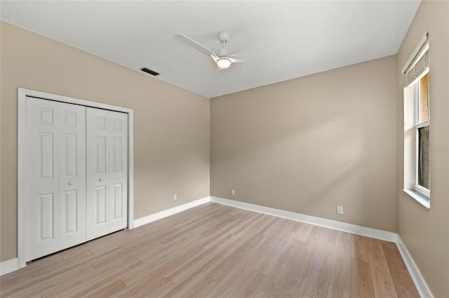 unfurnished bedroom with visible vents, a closet, baseboards, ceiling fan, and light wood-style flooring