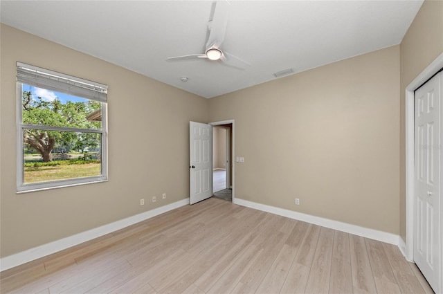unfurnished bedroom with a ceiling fan, visible vents, light wood-type flooring, baseboards, and a closet