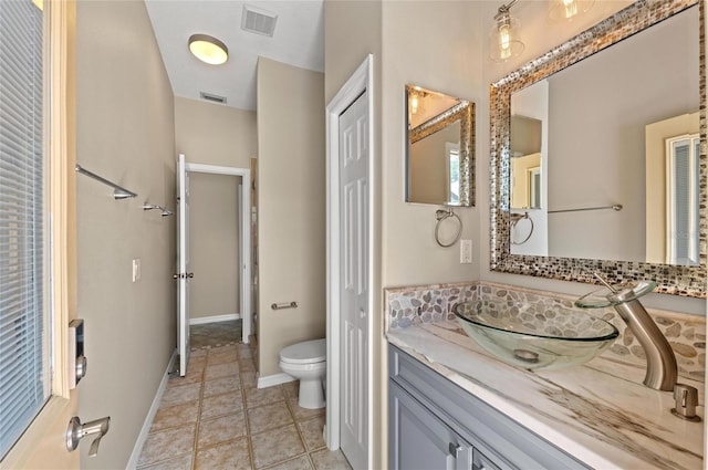 full bath featuring vanity, walk in shower, toilet, and visible vents