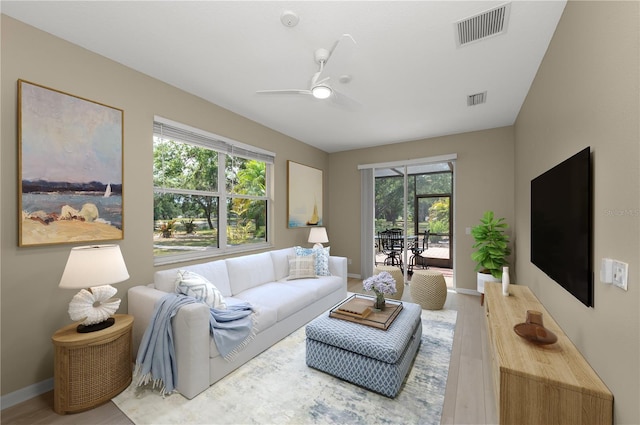 living room with visible vents, a healthy amount of sunlight, and wood finished floors