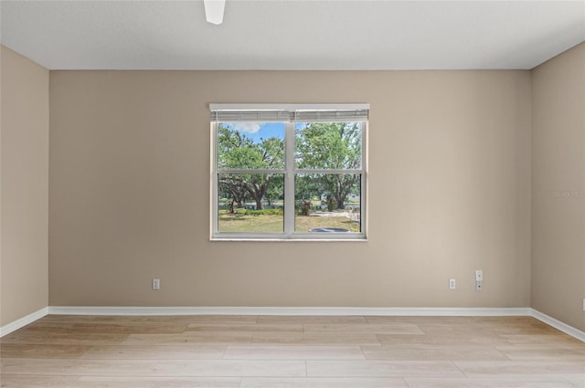 empty room with light wood-style floors and baseboards