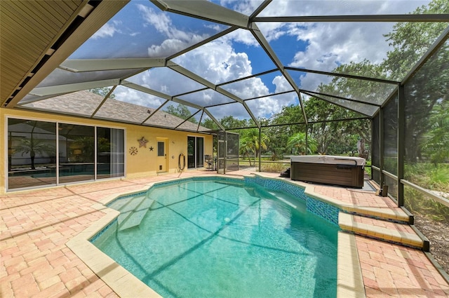 pool featuring a hot tub, a lanai, and a patio area