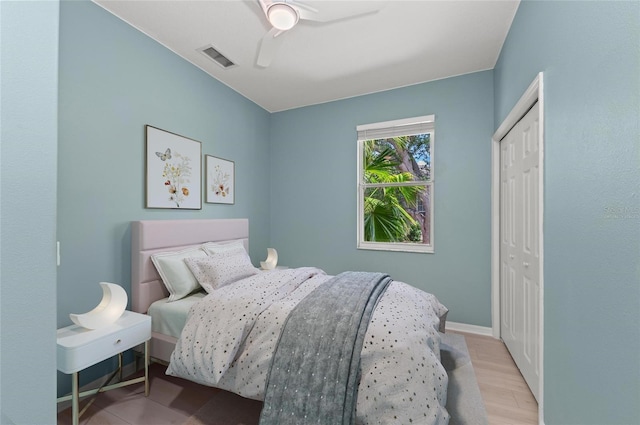 bedroom featuring ceiling fan, visible vents, baseboards, and a closet