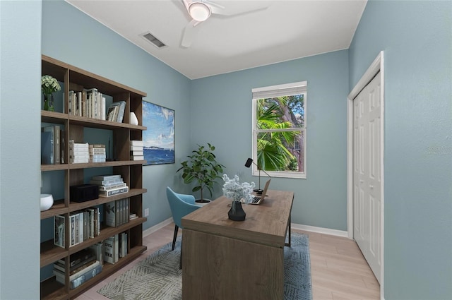 office space with baseboards, ceiling fan, wood finished floors, and visible vents