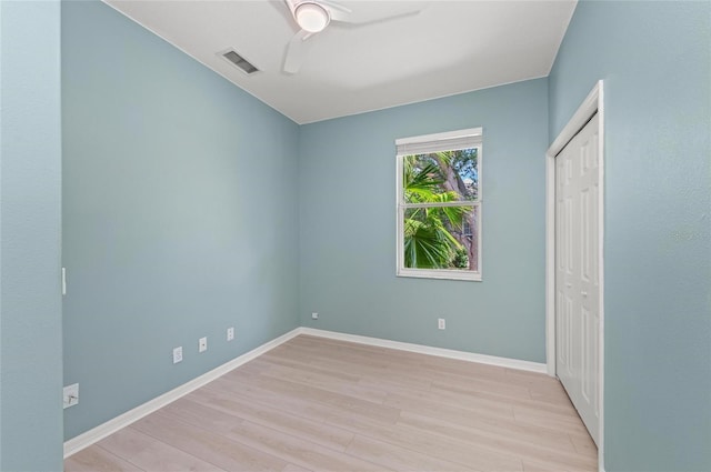 unfurnished bedroom featuring visible vents, a closet, baseboards, a ceiling fan, and light wood-style flooring