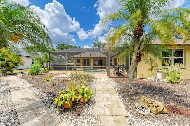 back of house featuring stucco siding, a lanai, a patio area, and an outdoor pool