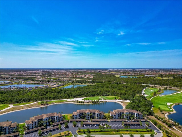 drone / aerial view featuring golf course view and a water view
