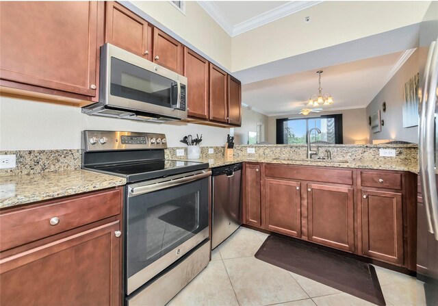kitchen with light stone countertops, an inviting chandelier, a sink, stainless steel appliances, and ornamental molding