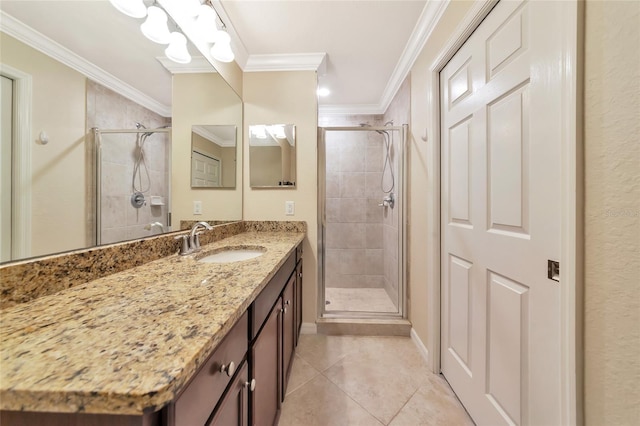 bathroom with tile patterned floors, a stall shower, ornamental molding, and vanity