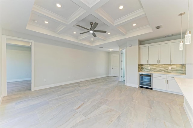 interior space featuring crown molding, coffered ceiling, a ceiling fan, baseboards, and beverage cooler