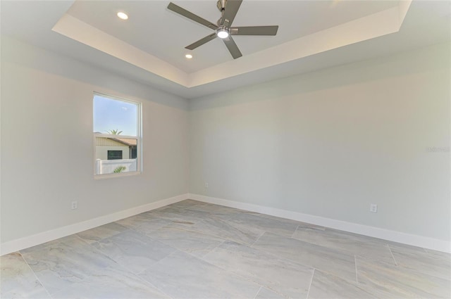 unfurnished room with recessed lighting, a tray ceiling, a ceiling fan, and baseboards