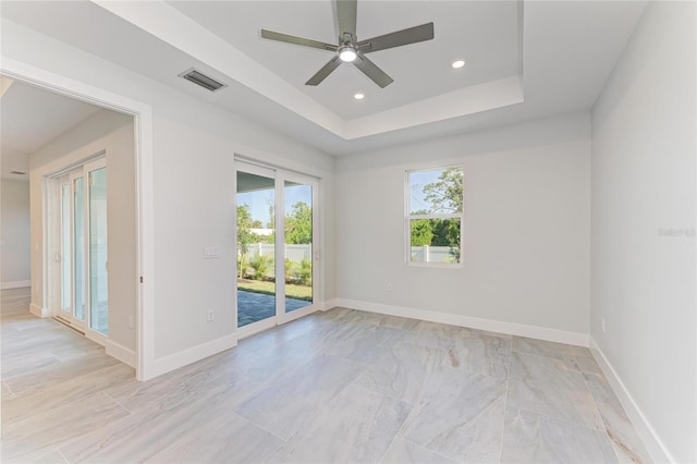 unfurnished room featuring recessed lighting, ceiling fan, a raised ceiling, visible vents, and baseboards
