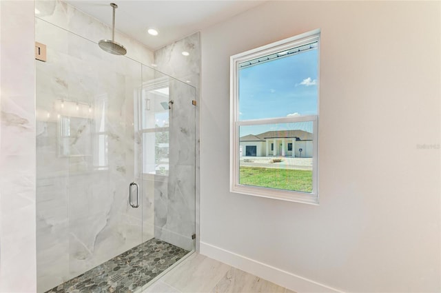 bathroom featuring recessed lighting, a marble finish shower, and baseboards