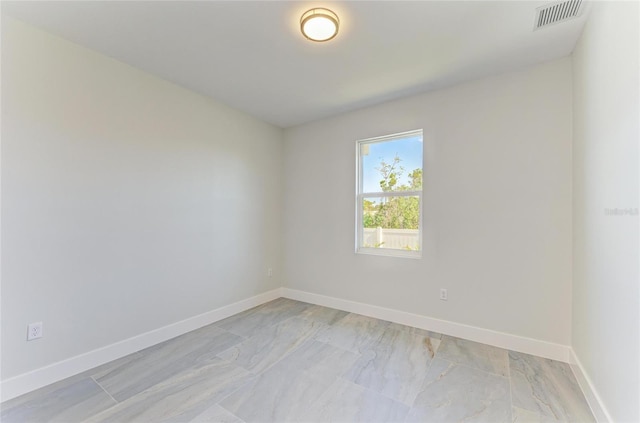 empty room featuring visible vents, marble finish floor, and baseboards