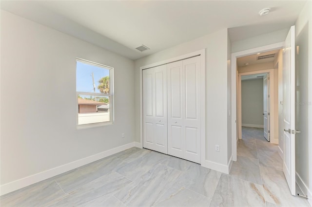 unfurnished bedroom featuring visible vents, a closet, and baseboards