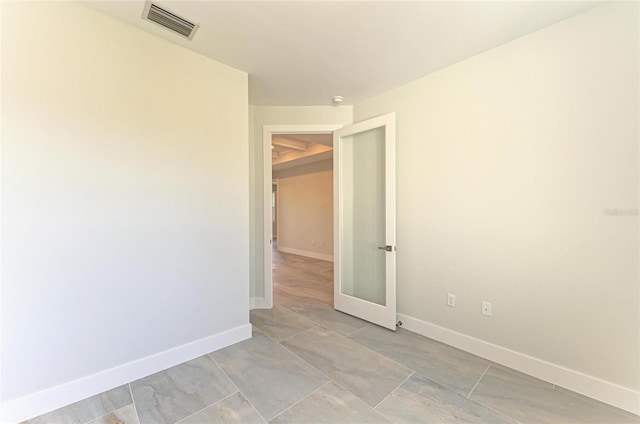 empty room with baseboards and visible vents