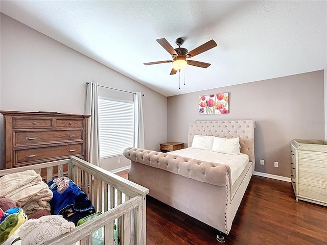 bedroom featuring baseboards, a ceiling fan, dark wood-style flooring, and vaulted ceiling