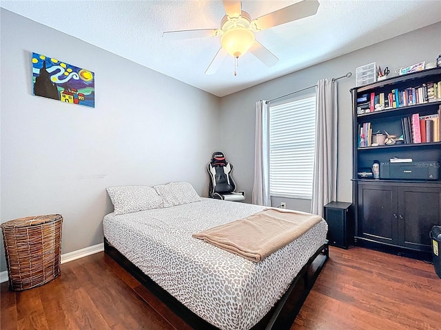 bedroom featuring baseboards, ceiling fan, and wood finished floors