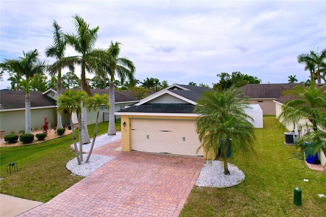 ranch-style house featuring an attached garage, stucco siding, a front lawn, and decorative driveway