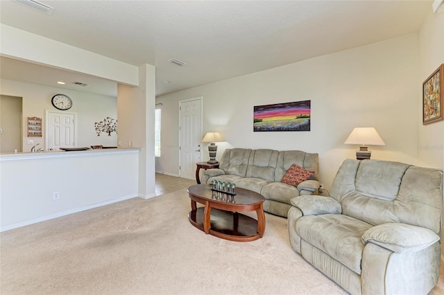 living area with baseboards, visible vents, and carpet