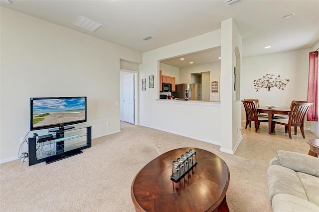 living area with light colored carpet, visible vents, and recessed lighting