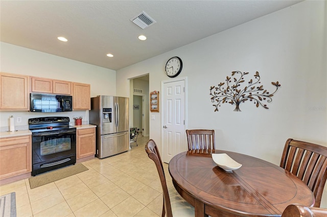 kitchen with black appliances, visible vents, light countertops, and light brown cabinetry