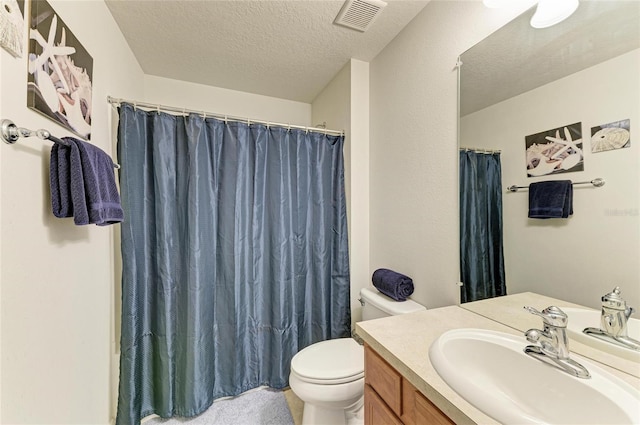 bathroom featuring a shower with curtain, vanity, toilet, visible vents, and a textured ceiling