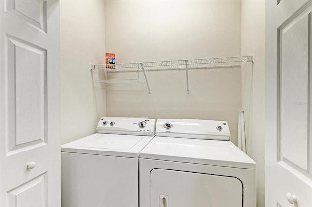 clothes washing area with independent washer and dryer and laundry area