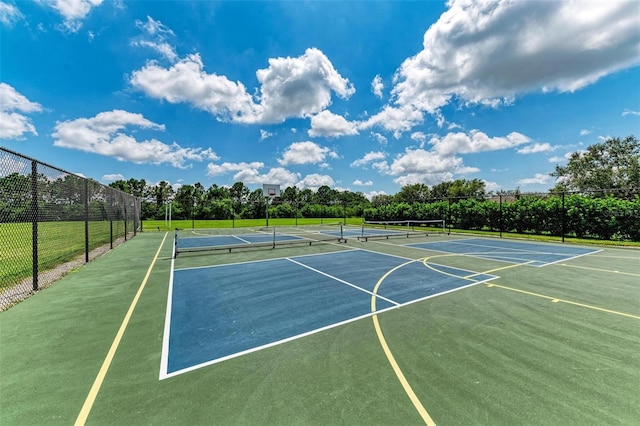 view of basketball court with fence, a tennis court, and community basketball court